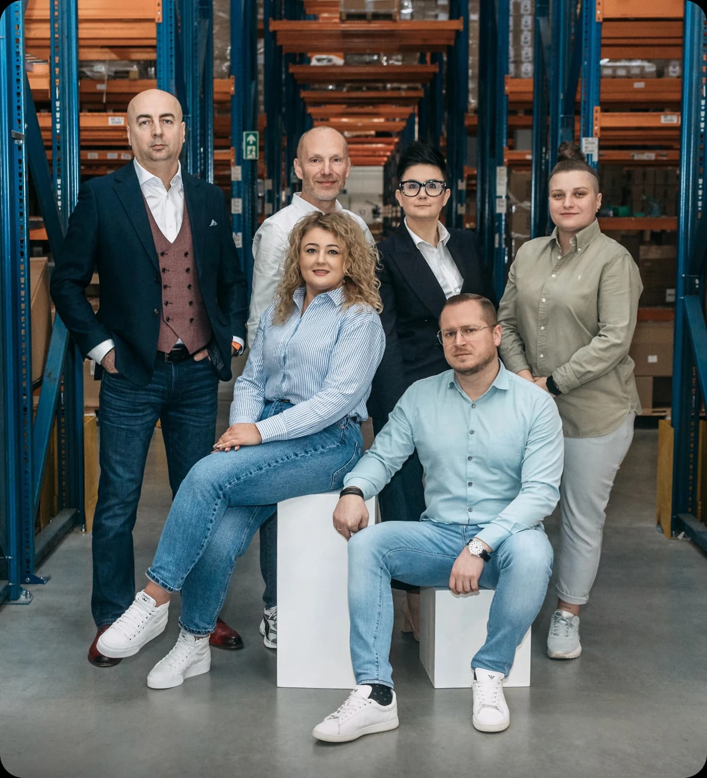Completio's management team in front of warehouse racking