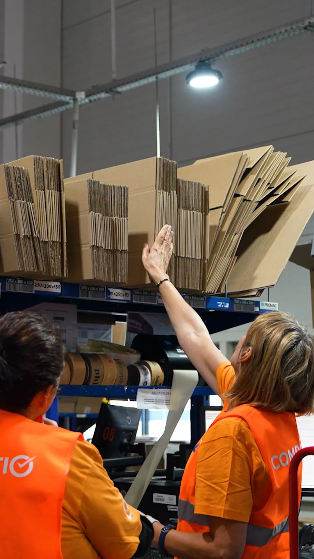 Kitting stations at the Completio warehouse: folding cartons, taping and sorting parcels