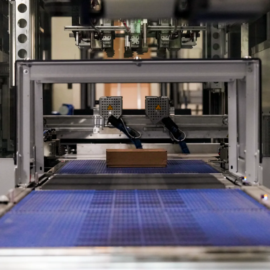 The Completio packing robot: a carton on the conveyor under the machine