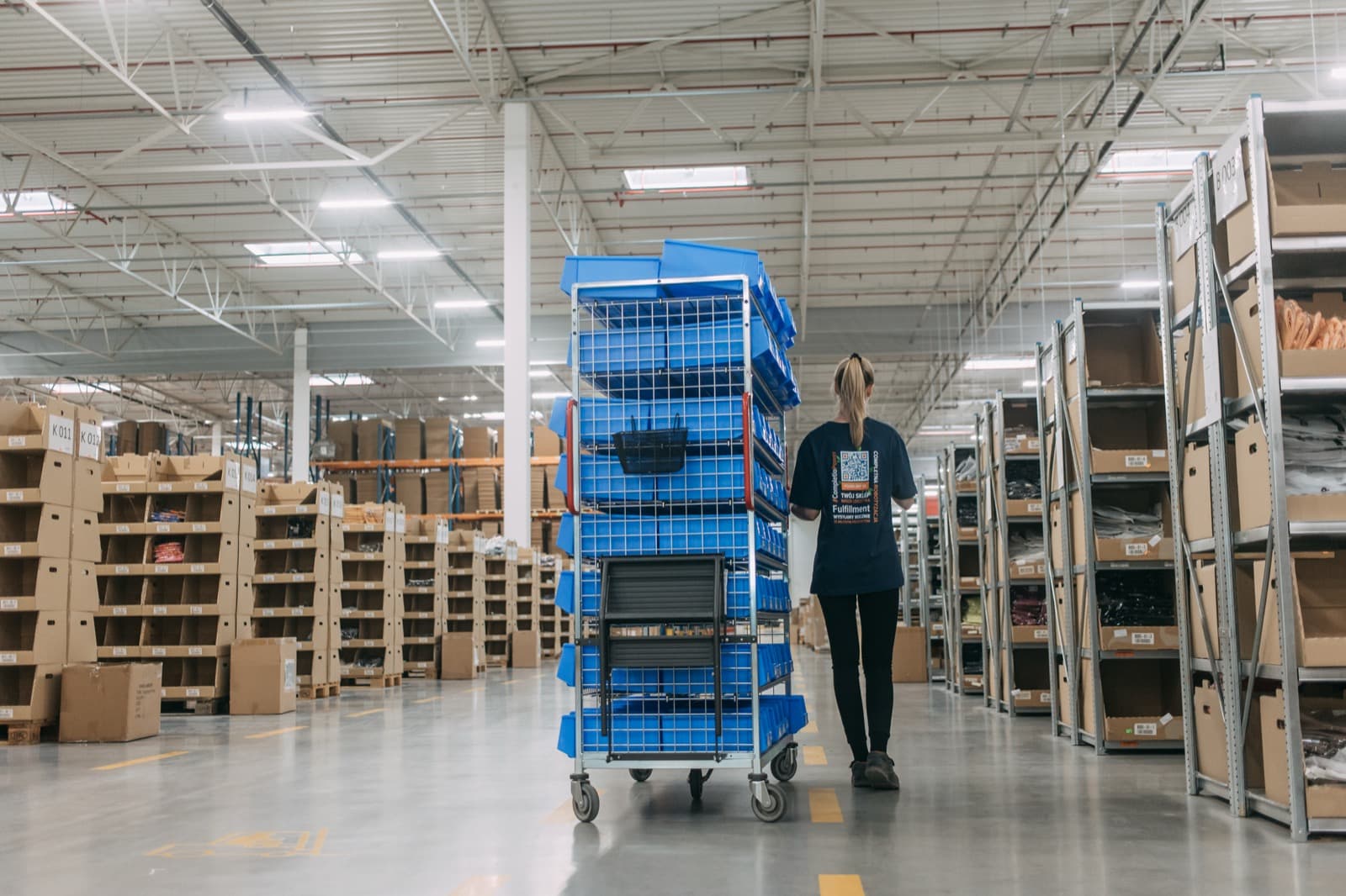 Kit assembly: a Completio employee with a picking cart in the warehouse aisle