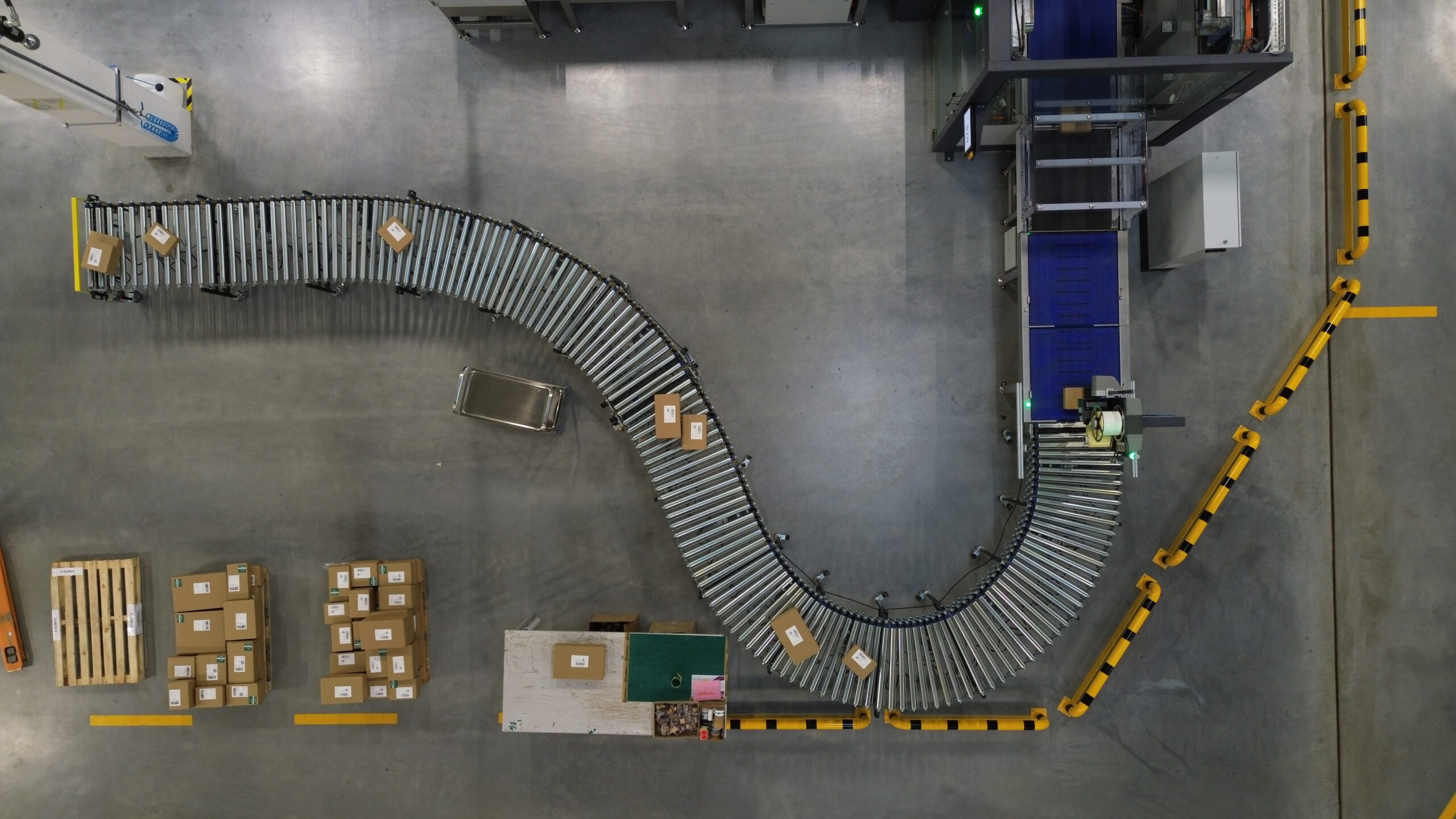 Widok z góry na zautomatyzowaną linię pakującą Completio z robotem przygotowującym do 1200 paczek na godzinę.